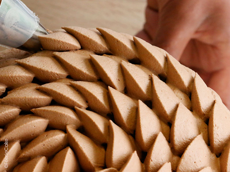 Le montage avec la douille St Honoré de l'entremet chocolat, noisette et caramel