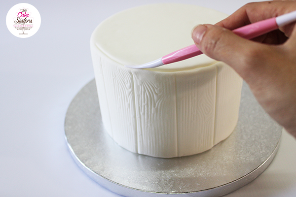 Gâteau recouvert de pâte à sucre blanche effet tronc d'arbre